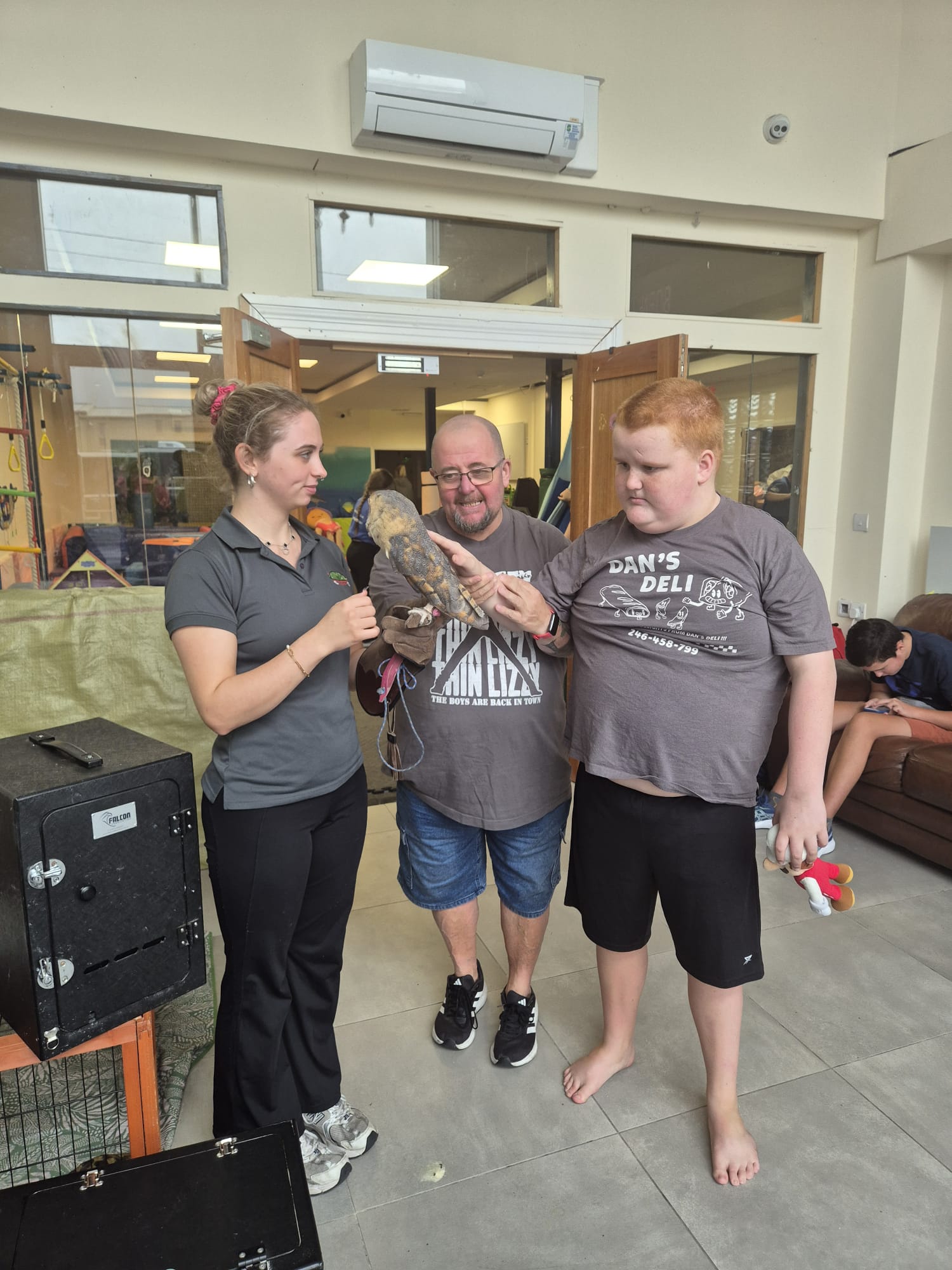 Campers meeting an owl during an animal visit at the ASD Ireland summer camp.