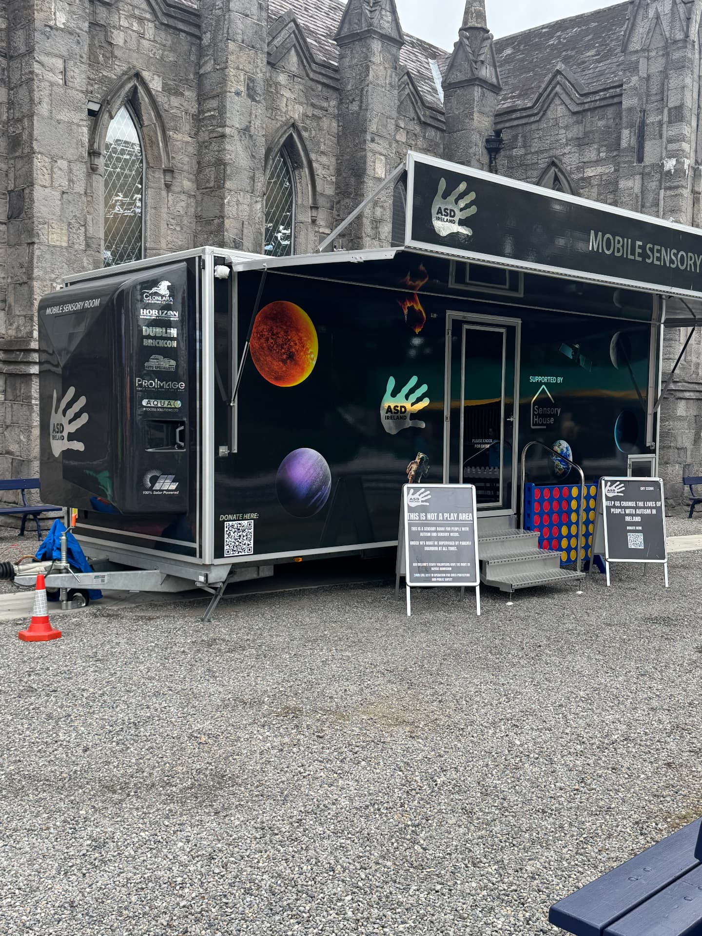 The ASD Ireland mobile sensory room trailer parked outside a stone church at the RDS.