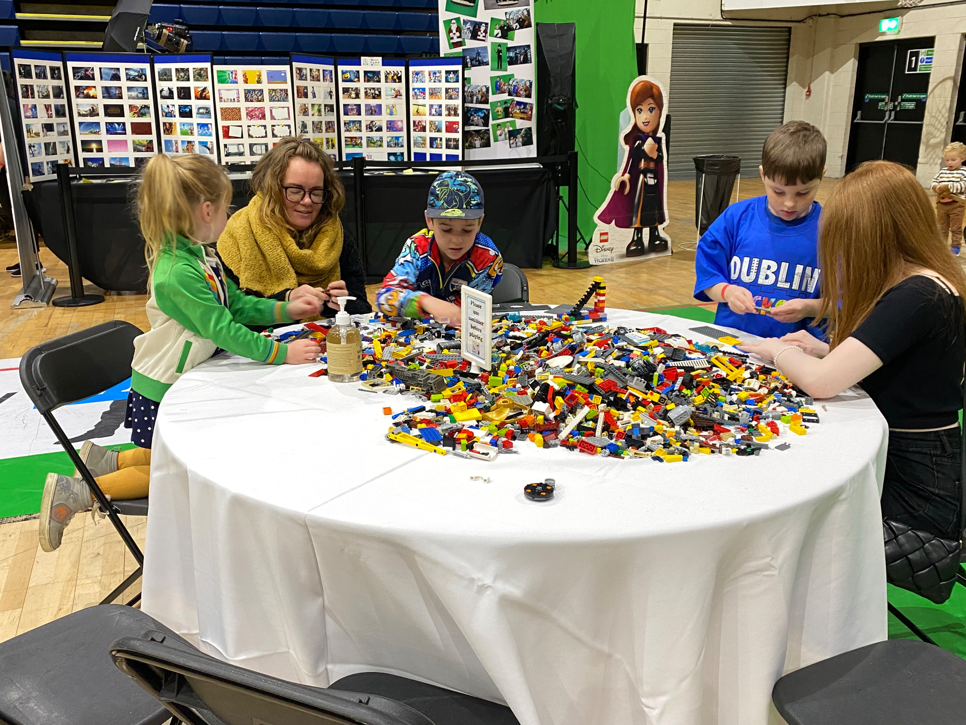 Children and parents building together around a table covered in colourful bricks at Dublin Brickcon.