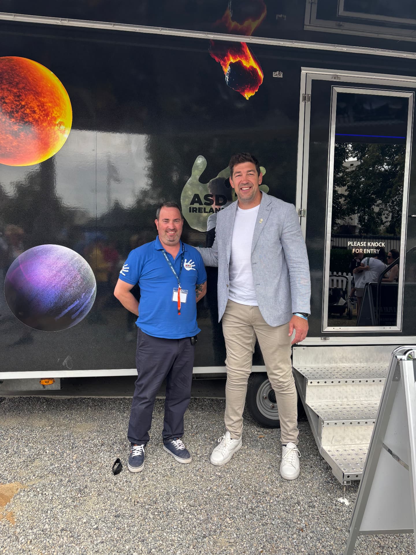 Two men standing in front of the ASD Ireland mobile sensory room at the Dublin Horse Show.